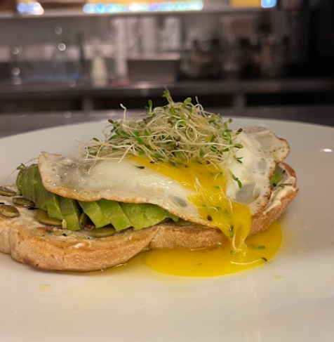 Avocado toast with poached egg and runny yolk